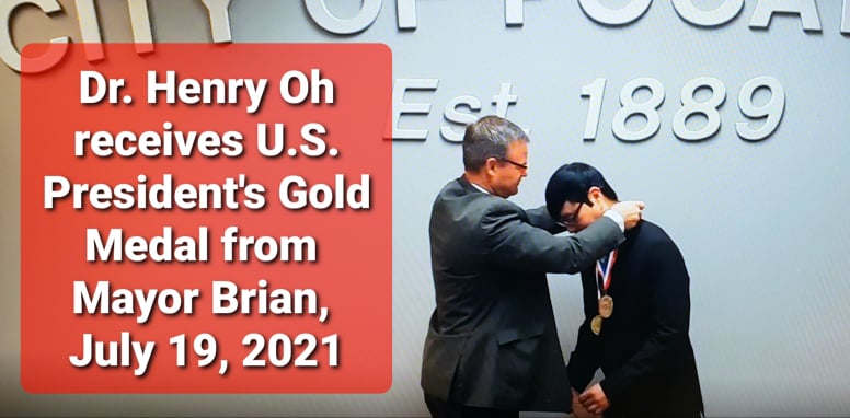 Dr. Henry Oh receives medal from Mayor Brian