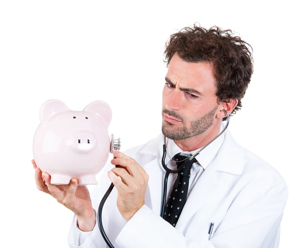 Closeup portrait, young curious male man healthcare professional, doctor, nurse listening to piggy bank with stethoscope. Medical insurance, medicare reimbursement concept . Health-law coverage gap