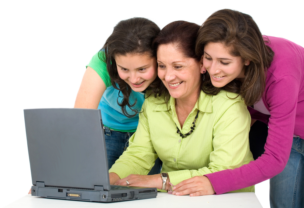 happy family formed by the mother and two daughters on a laptop computer - isolated over a white background